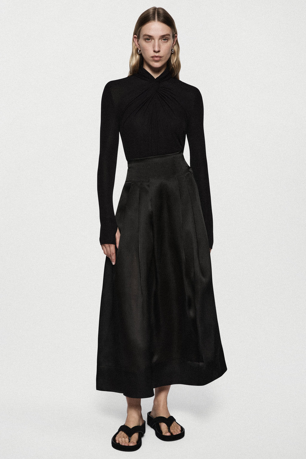 Black long-sleeve twist jersey top with ruched high neck and waistband seam