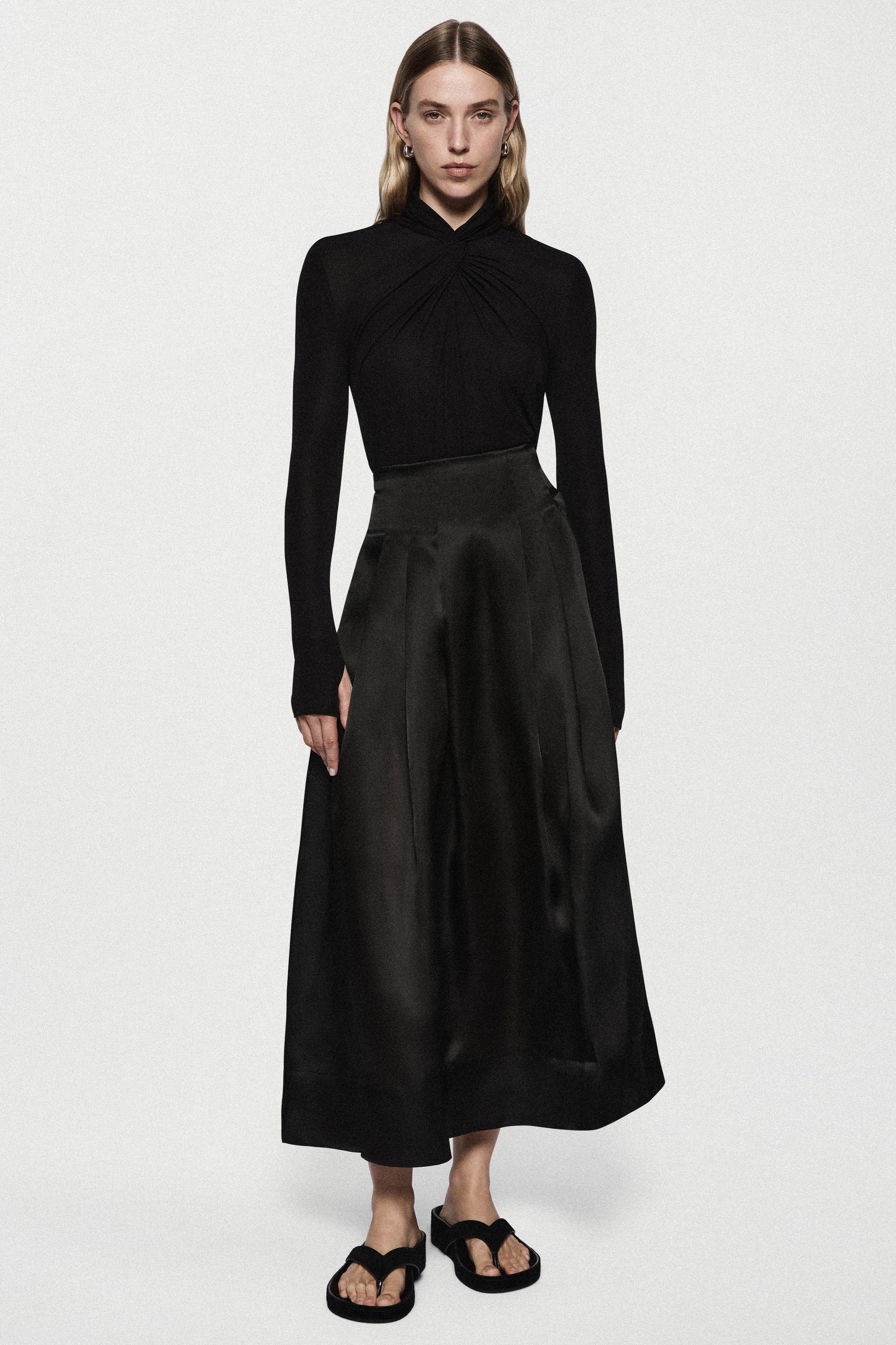 Black long-sleeve twist jersey top with ruched high neck and waistband seam