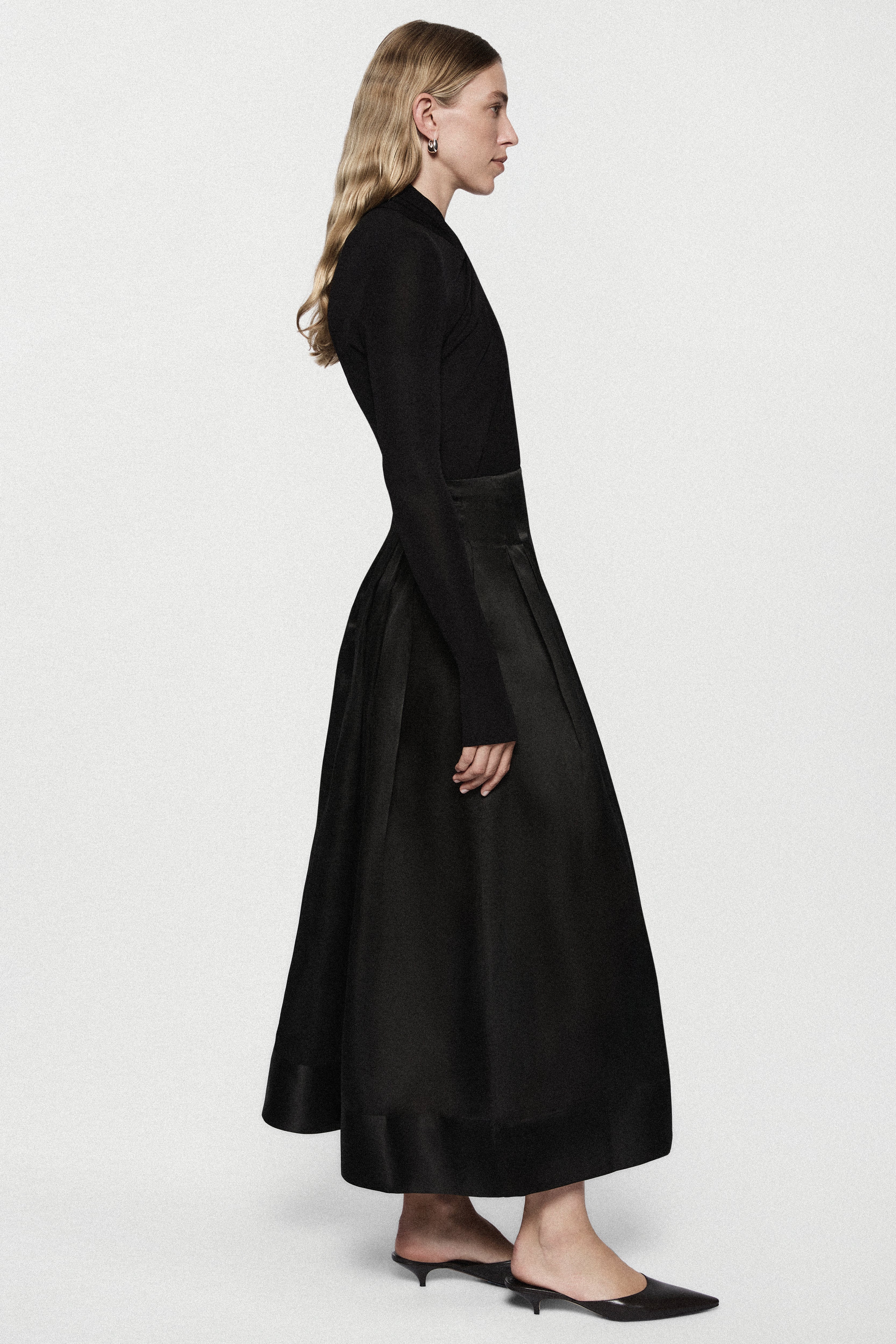 Black long-sleeve twist jersey top, side view, fitted waist seam