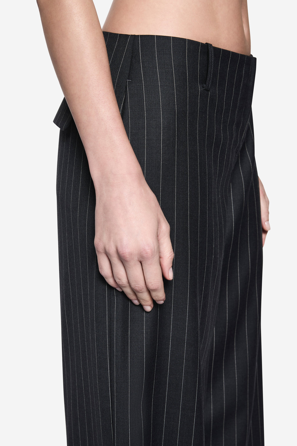 Charcoal pinstripe wool pants detail at waistband and front hand pocket