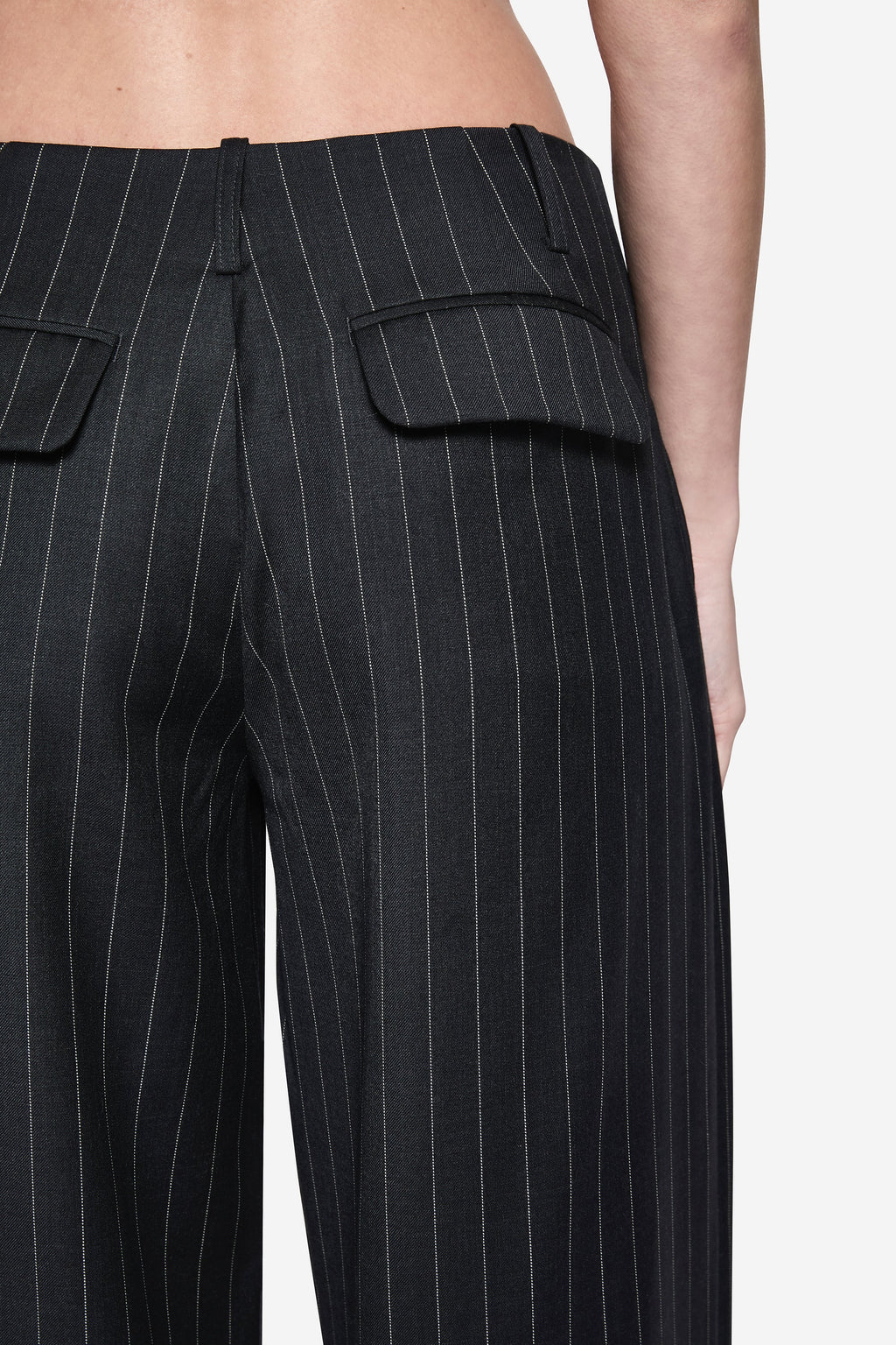 Close-up of charcoal wool pinstripe pants with pleats and flap pocket