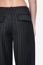 Close-up of charcoal wool pinstripe pants with pleats and flap pocket