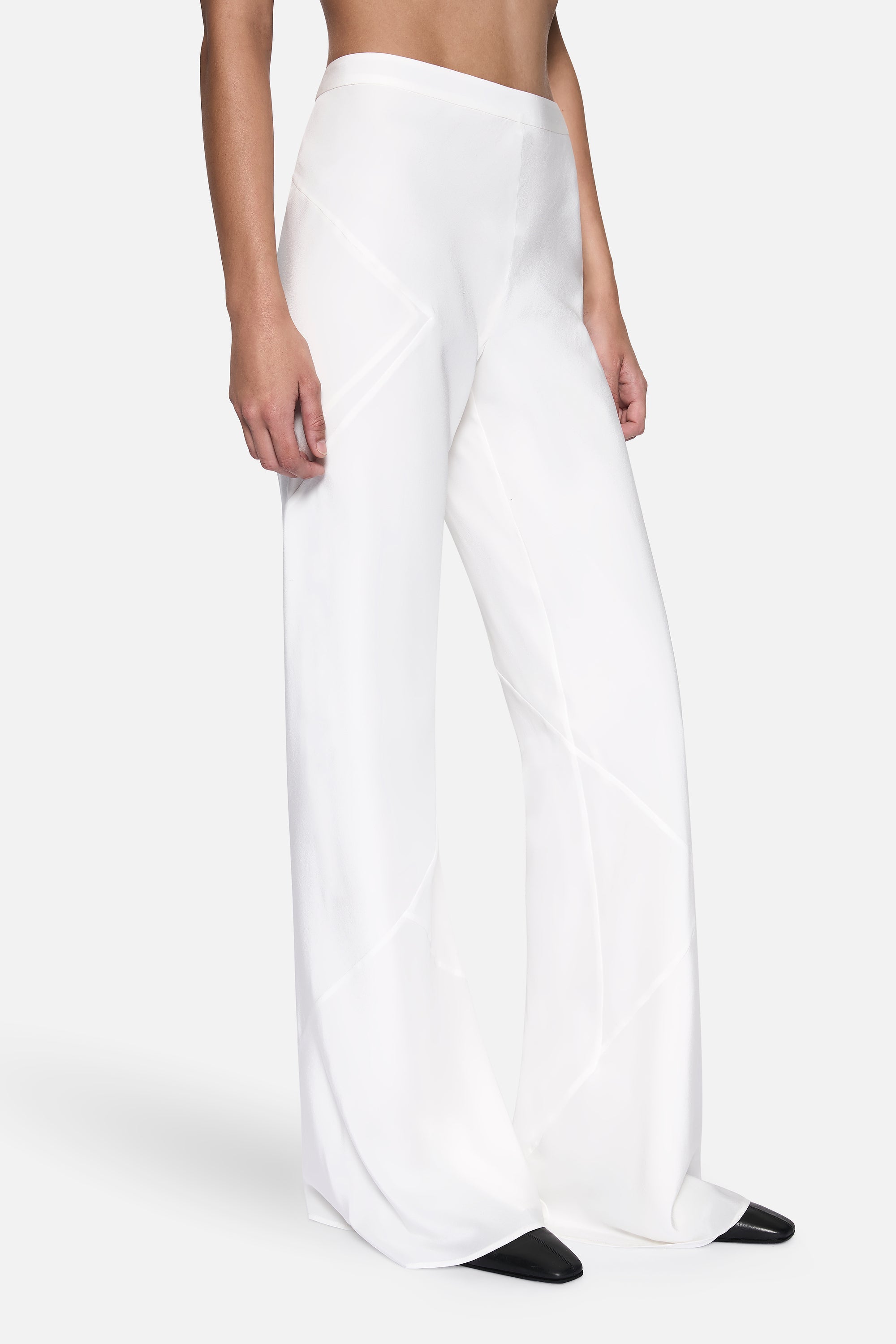 Ivory silk bias pants, side view with fluid drape and wide flared hem