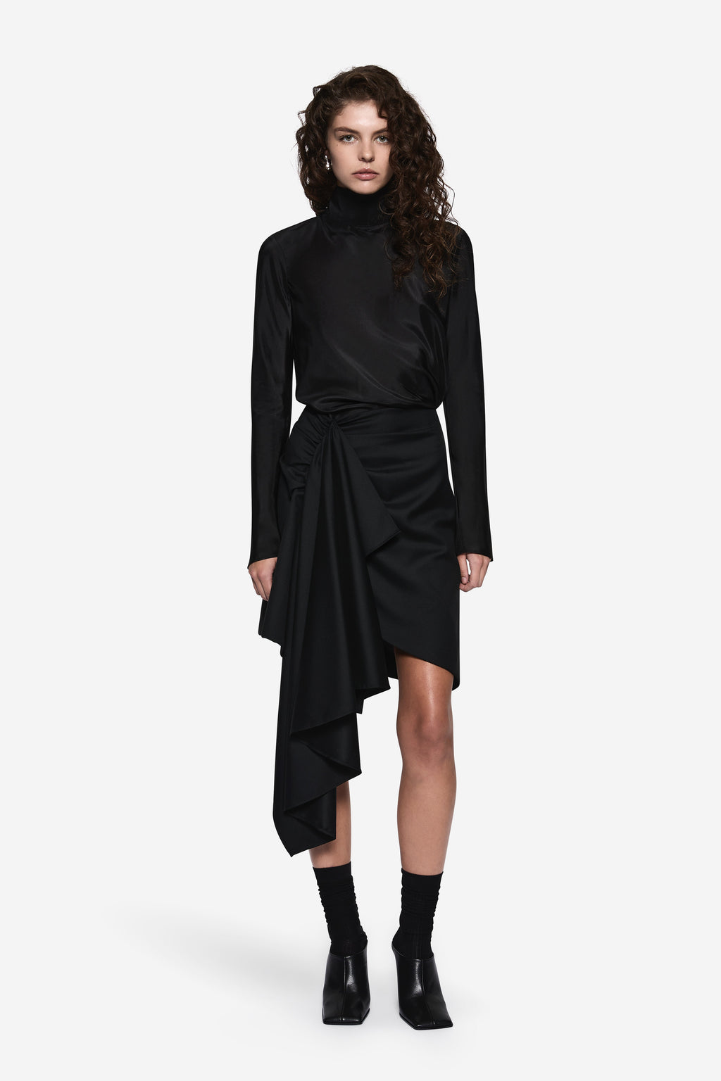 Black draped wool suiting skirt with wrap waist and offset asymmetric layered hem