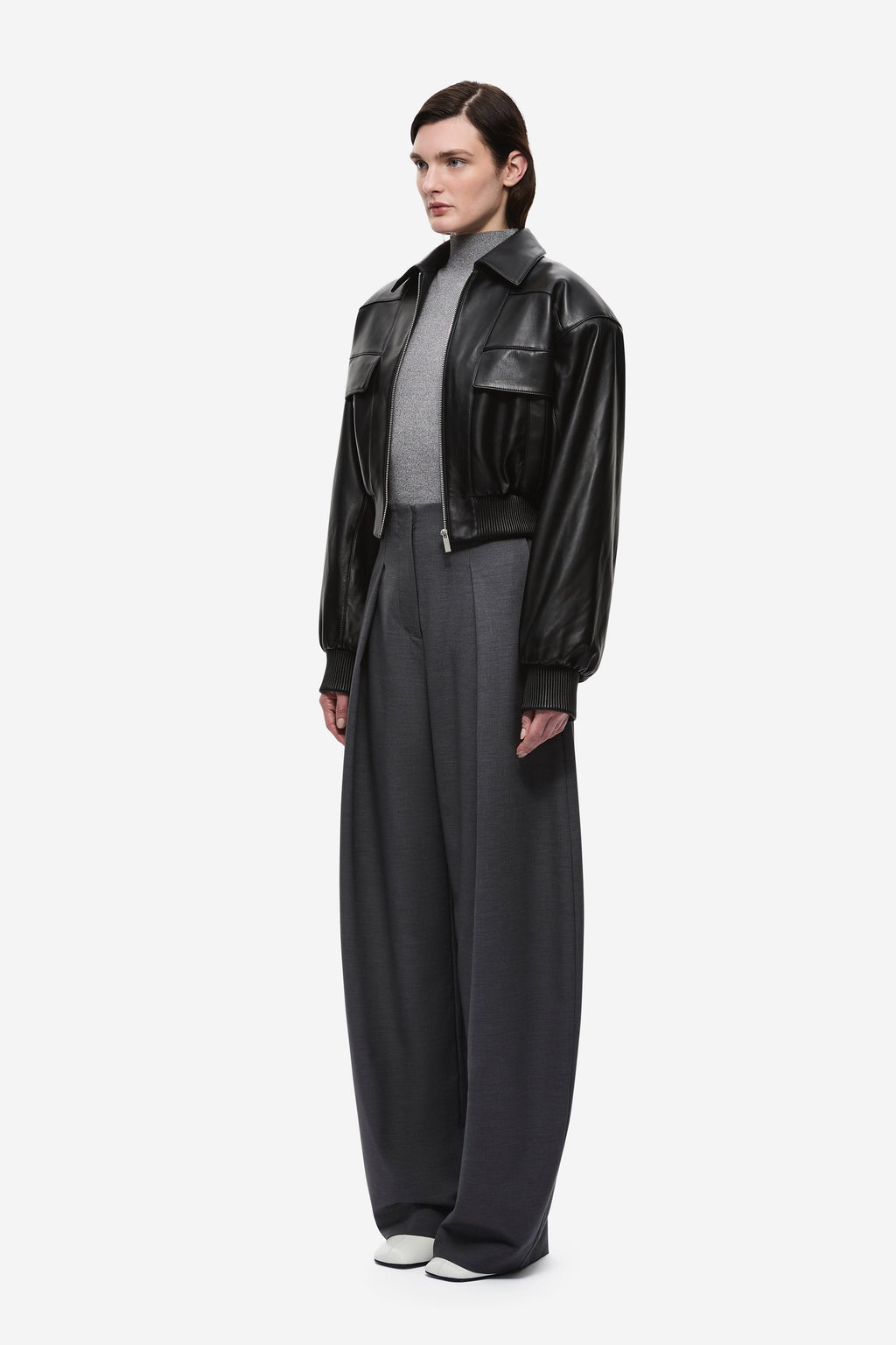 Black leather aviator jacket side view with snap collar and flap pockets