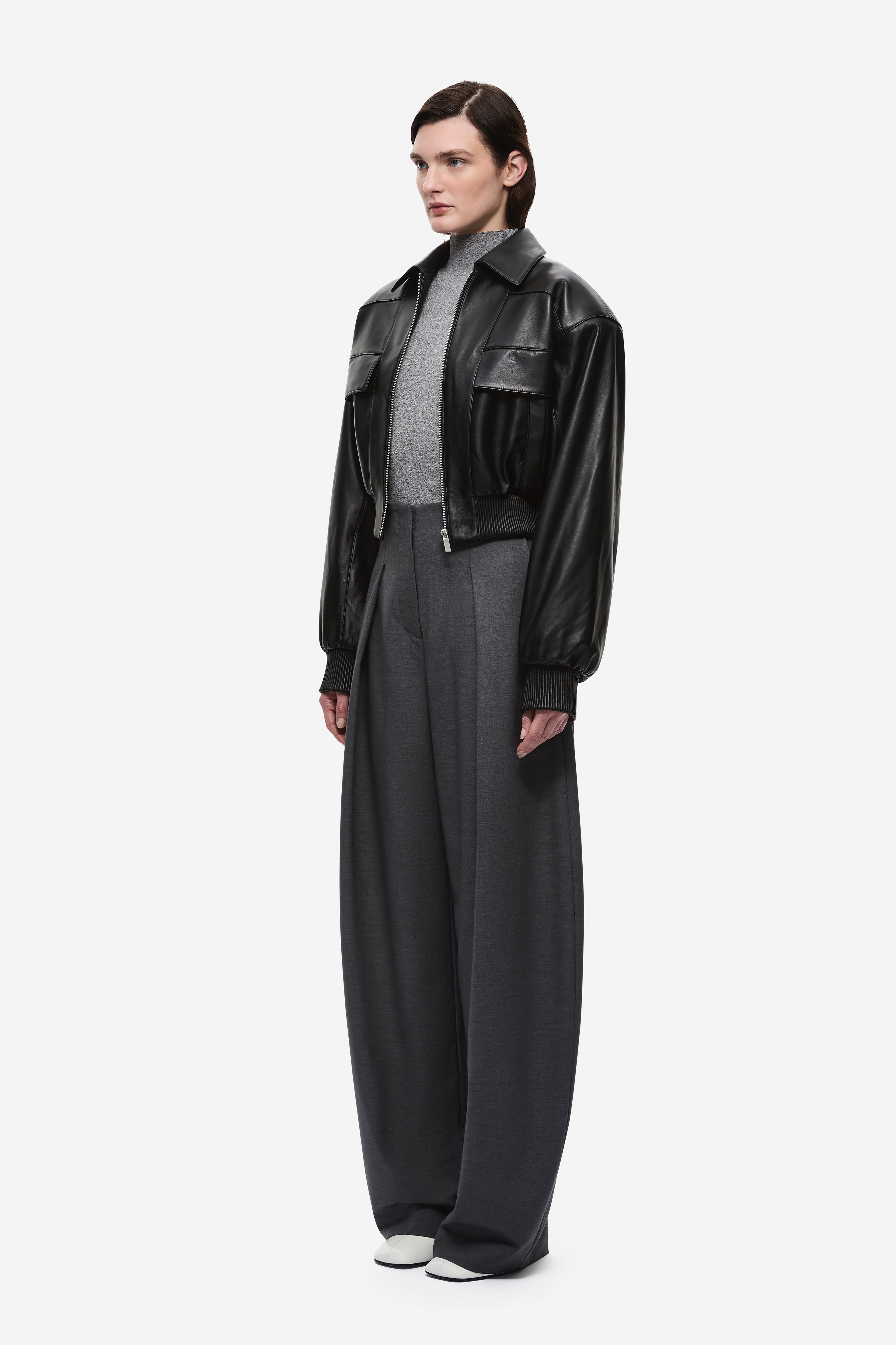 Black leather aviator jacket side view with snap collar and flap pockets