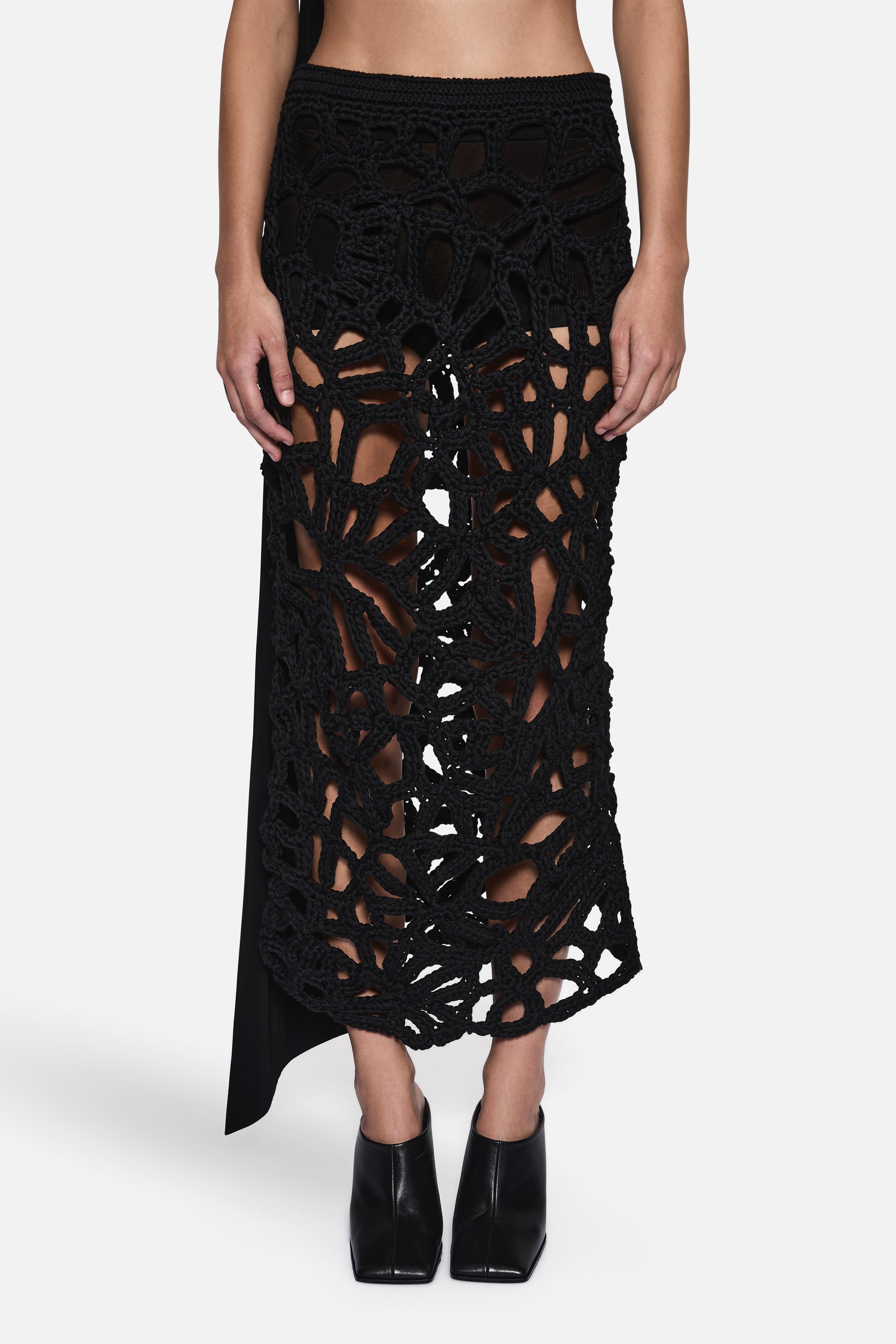 Black crochet midi skirt close-up with geometric openwork and layered hem
