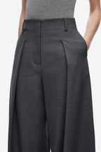 Dark grey pleated wide-leg pants close-up with belt loops and front seams