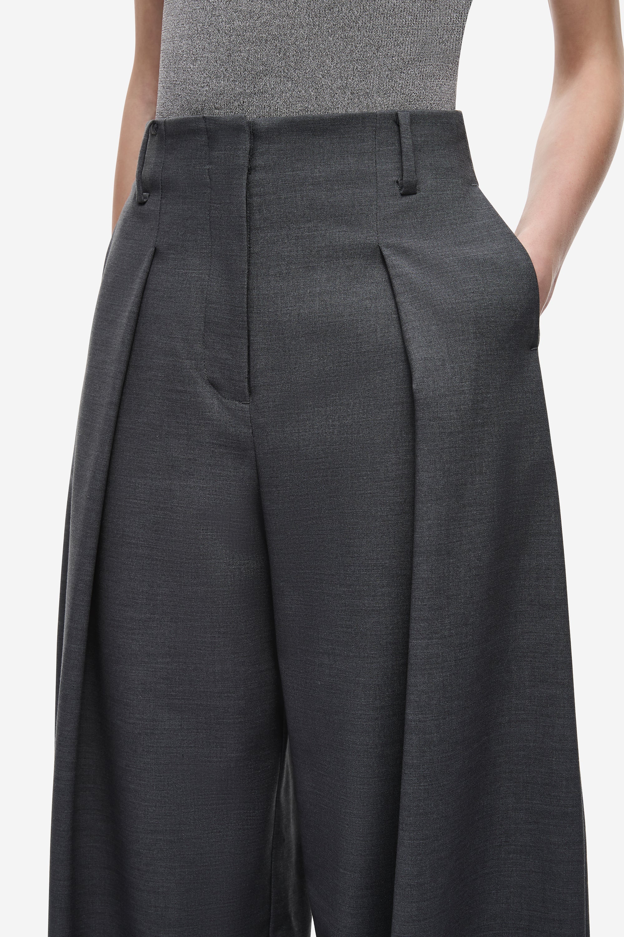 Dark grey pleated wide-leg pants close-up with belt loops and front seams