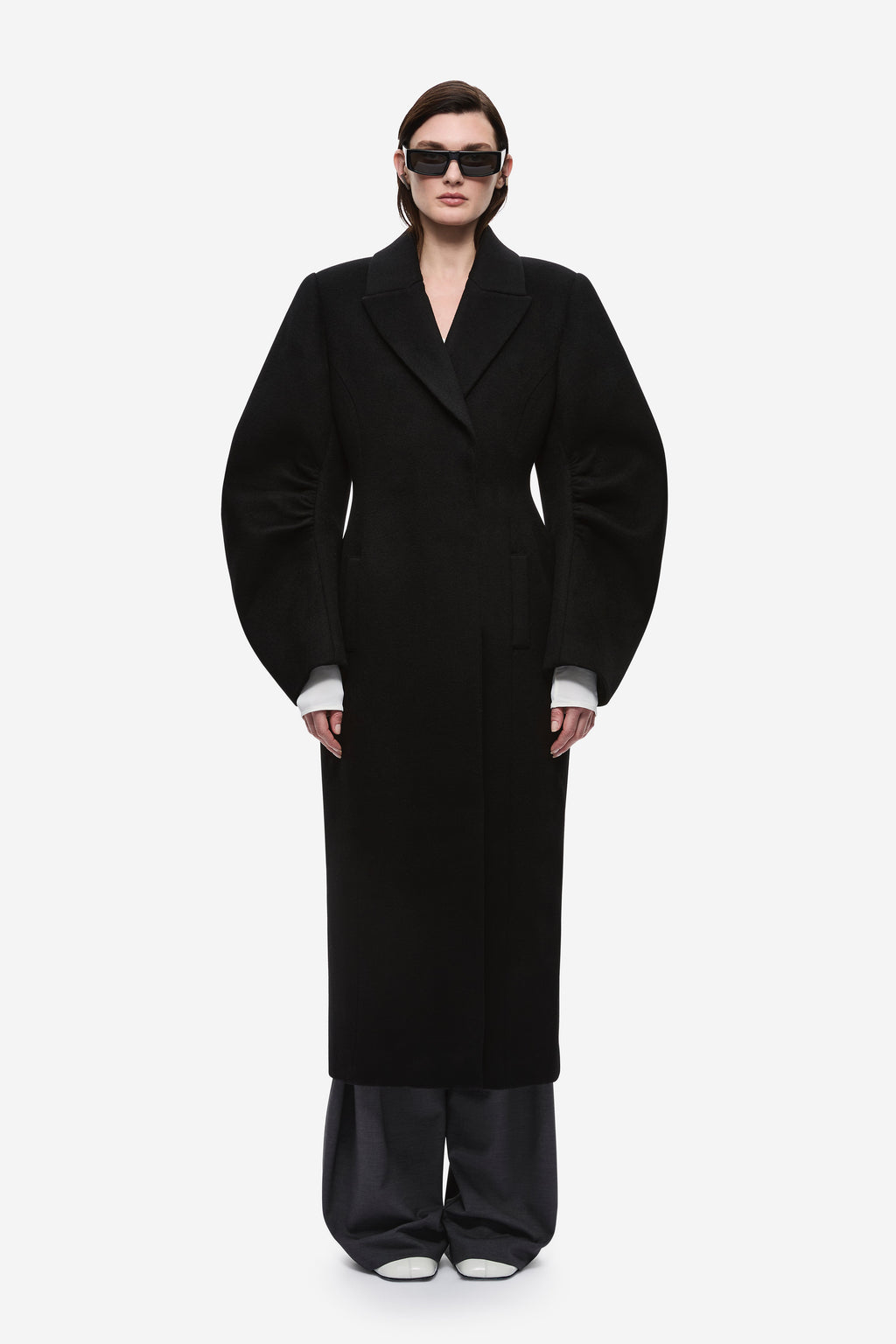 Black wool long coat with notched lapels and tailored single-breasted front.