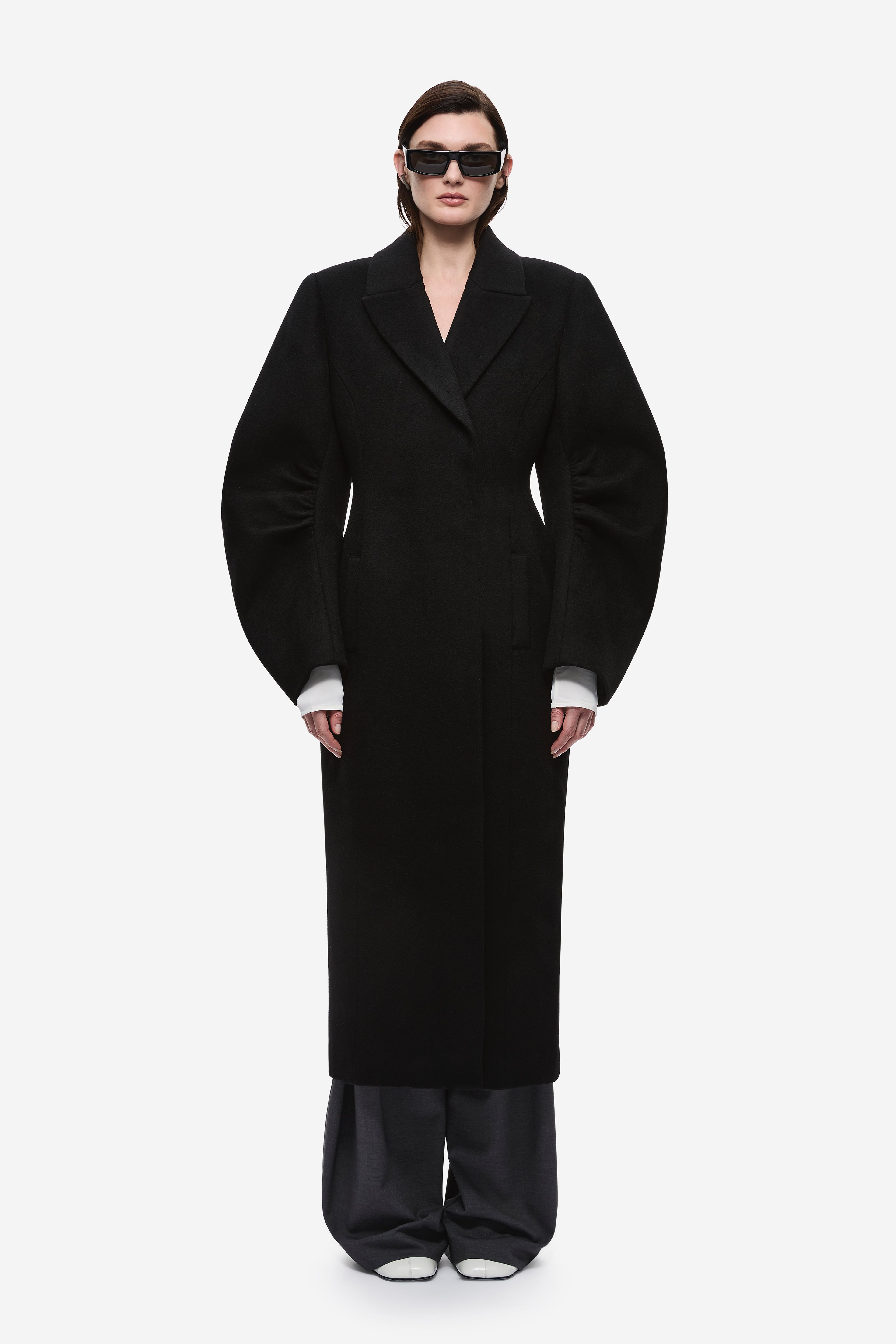Black wool long coat with notched lapels and tailored single-breasted front.