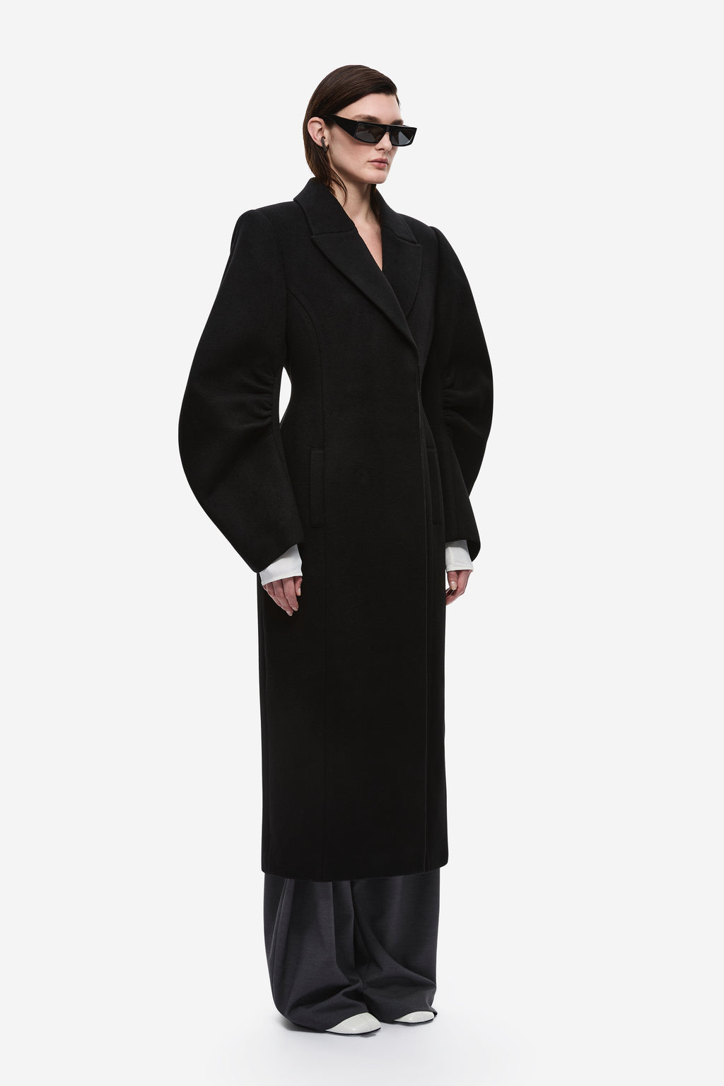 Black wool long coat with notched lapels, long sleeves, and straight hem.