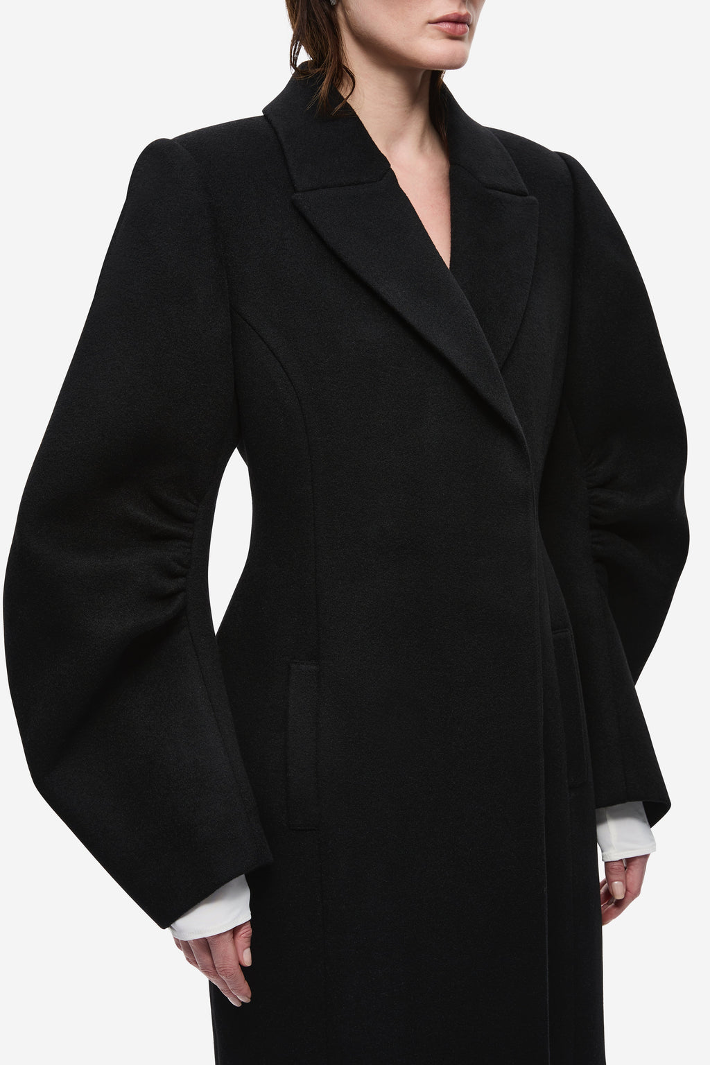 Black wool tailored long coat with notched lapels and deep V neckline detail.