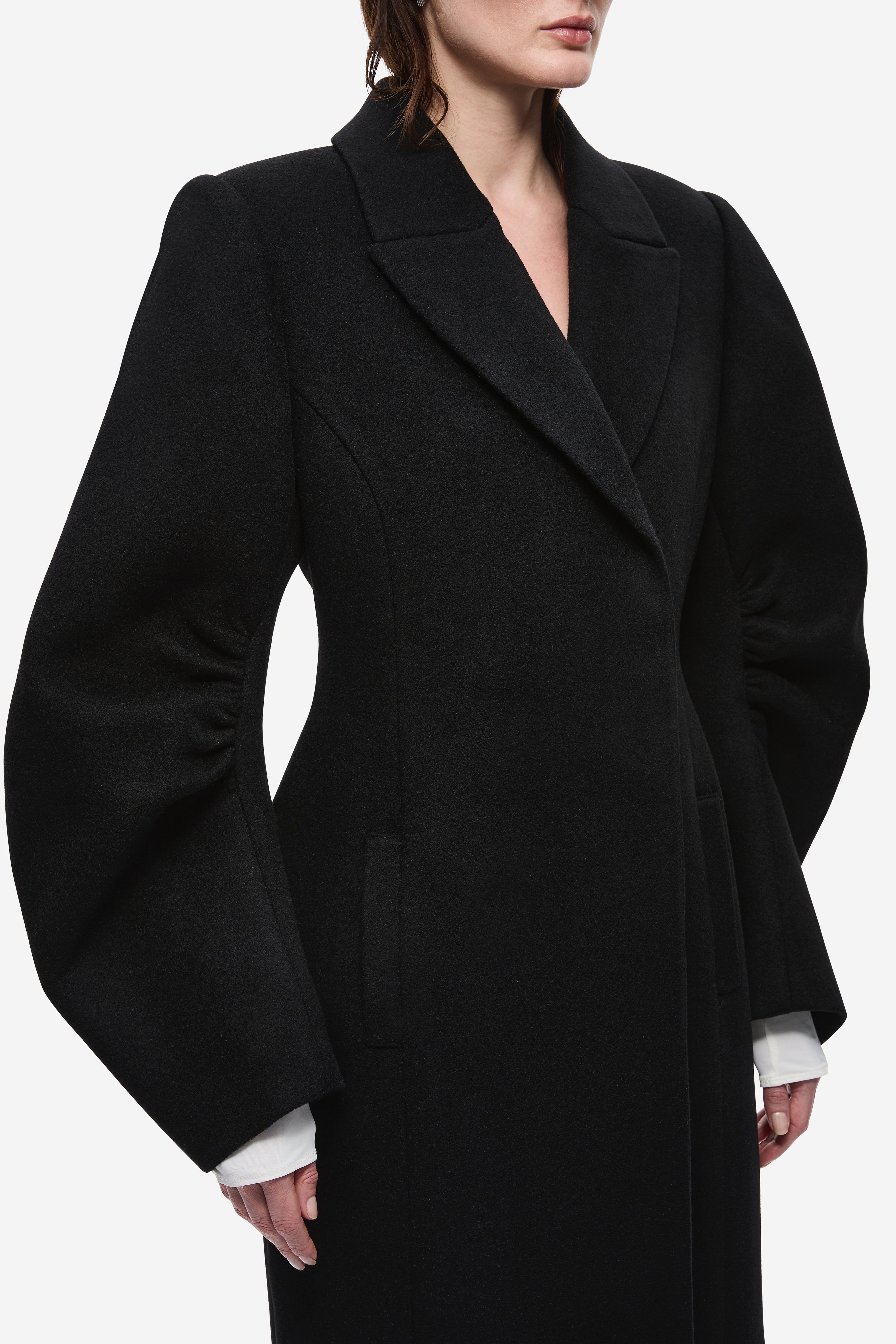 Black wool tailored long coat with notched lapels and deep V neckline detail.