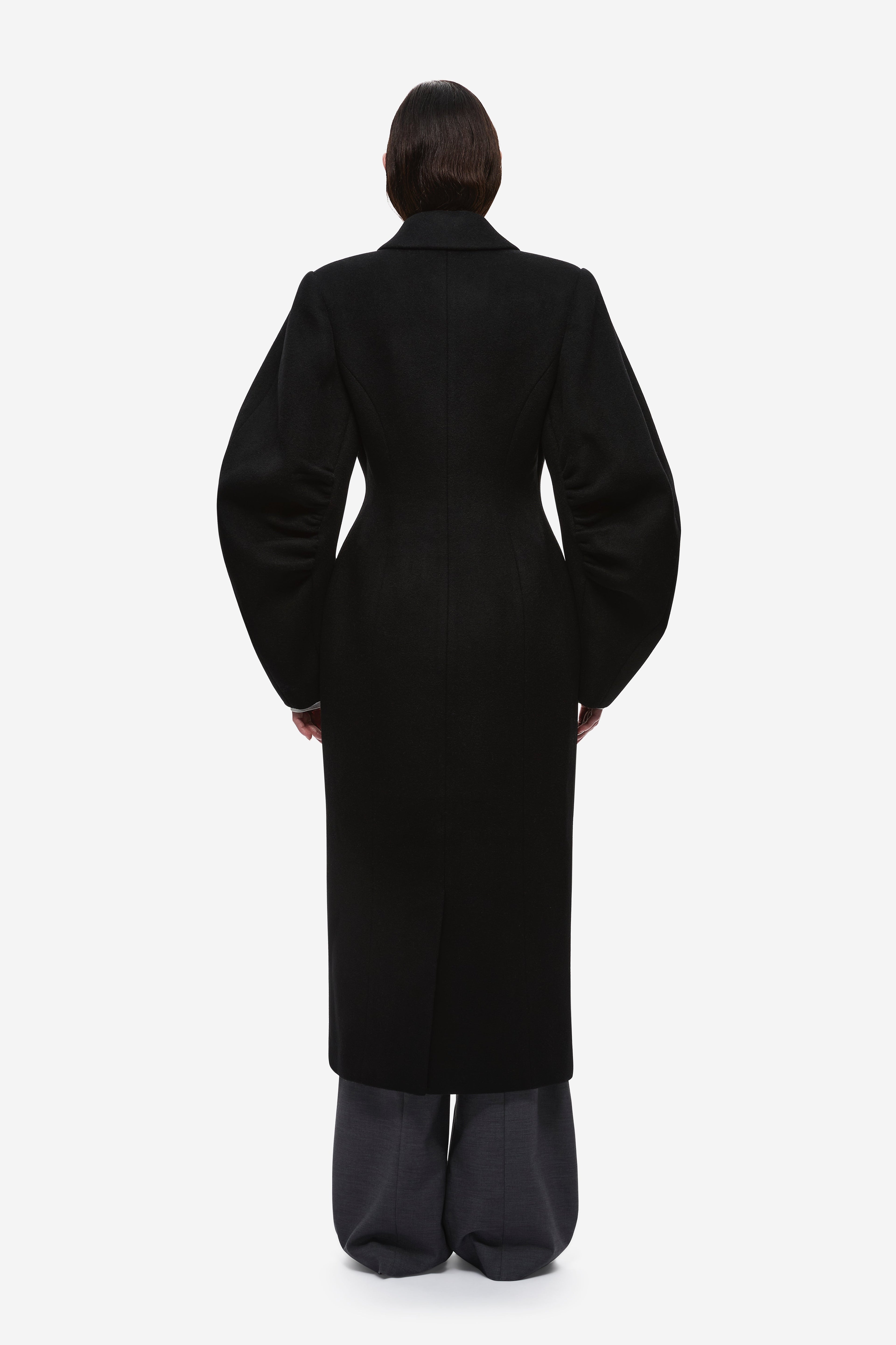 Back view of black wool long coat with center seam and notched collar.