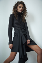Black draped wool suiting skirt with twisted waist and cascading asymmetric panel hem