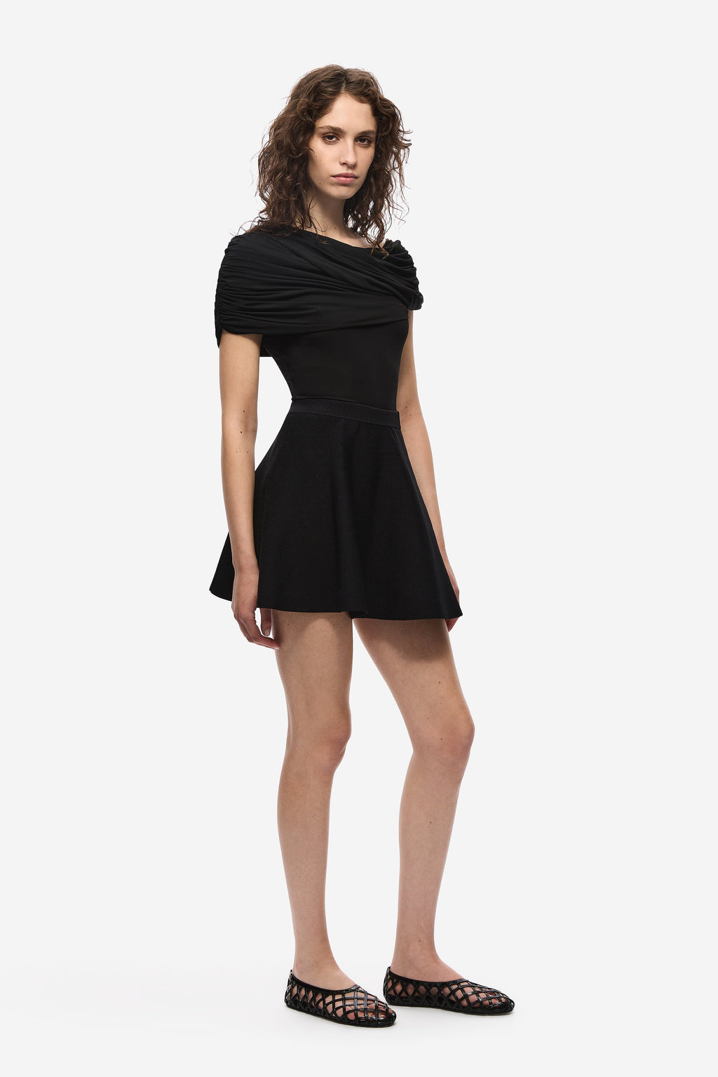 Black cowl-neck jersey top with draped sleeves and flared short hem