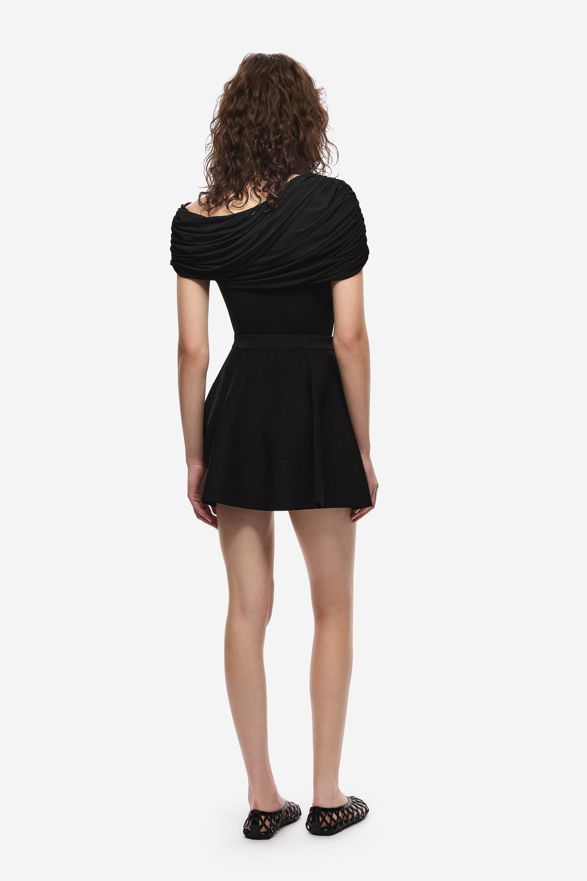 Black jersey top with back draped cowl detail and short flared hem