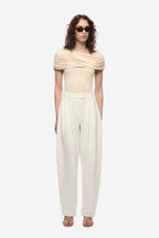 Pearl ivory jersey top with off-shoulder cowl drape, fitted short sleeves, front view.