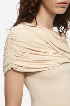 Close-up of pearled ivory draped cowl neckline jersey top with short sleeve gathers.